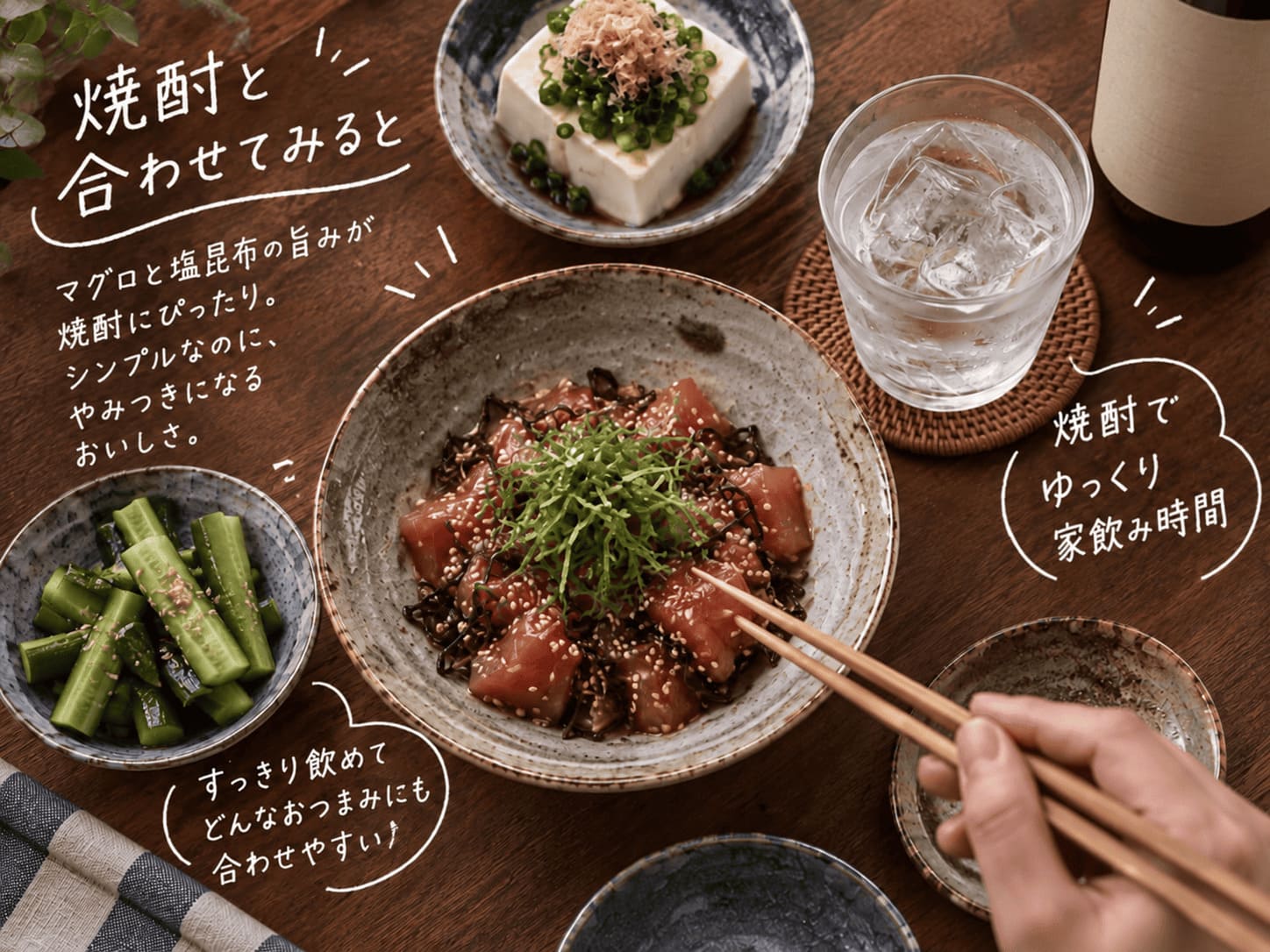 マグロの塩昆布和えと氷を入れた焼酎を並べた晩酌の食卓