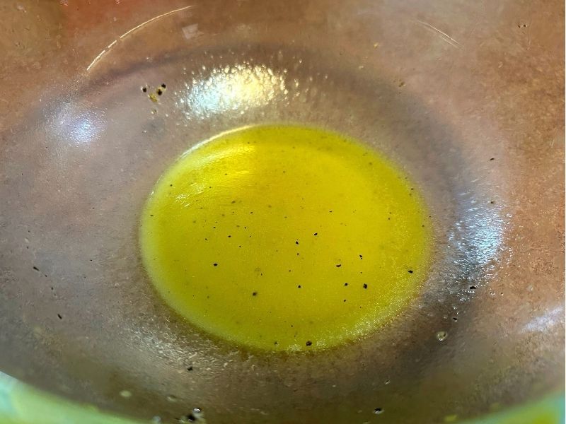 ガラスボウルで混ぜ合わせたケールサラダ用の手作りイタリアンドレッシング